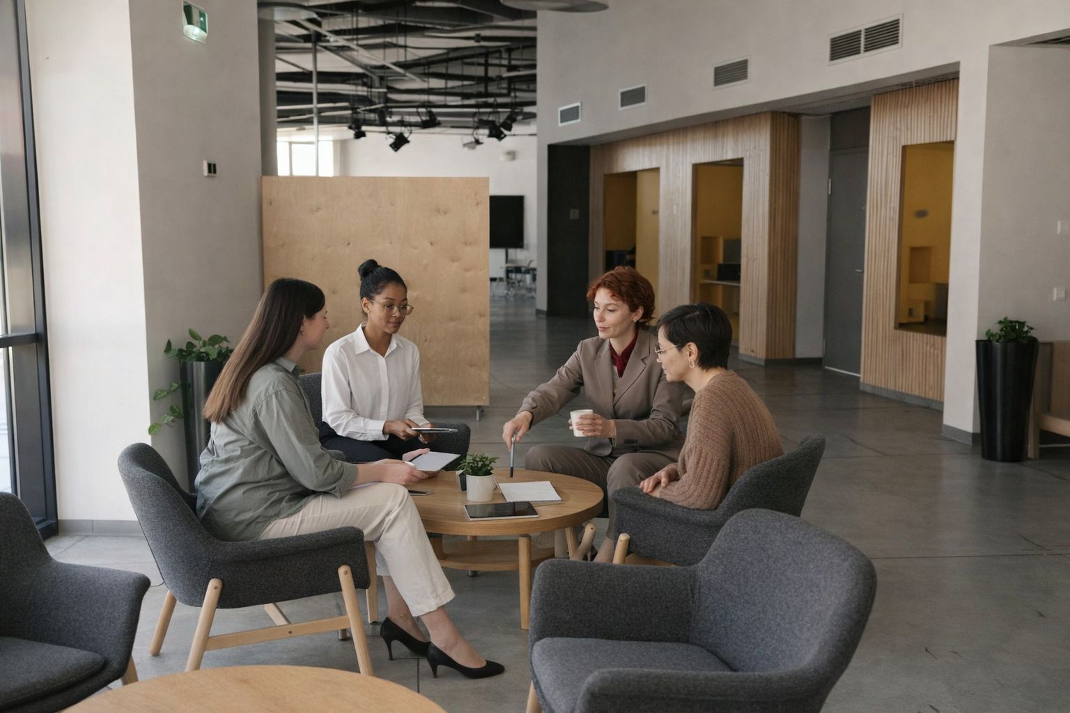 Fyra kvinnor i ett kreativt möte på ett modernt kontorshotell i Stockholm.