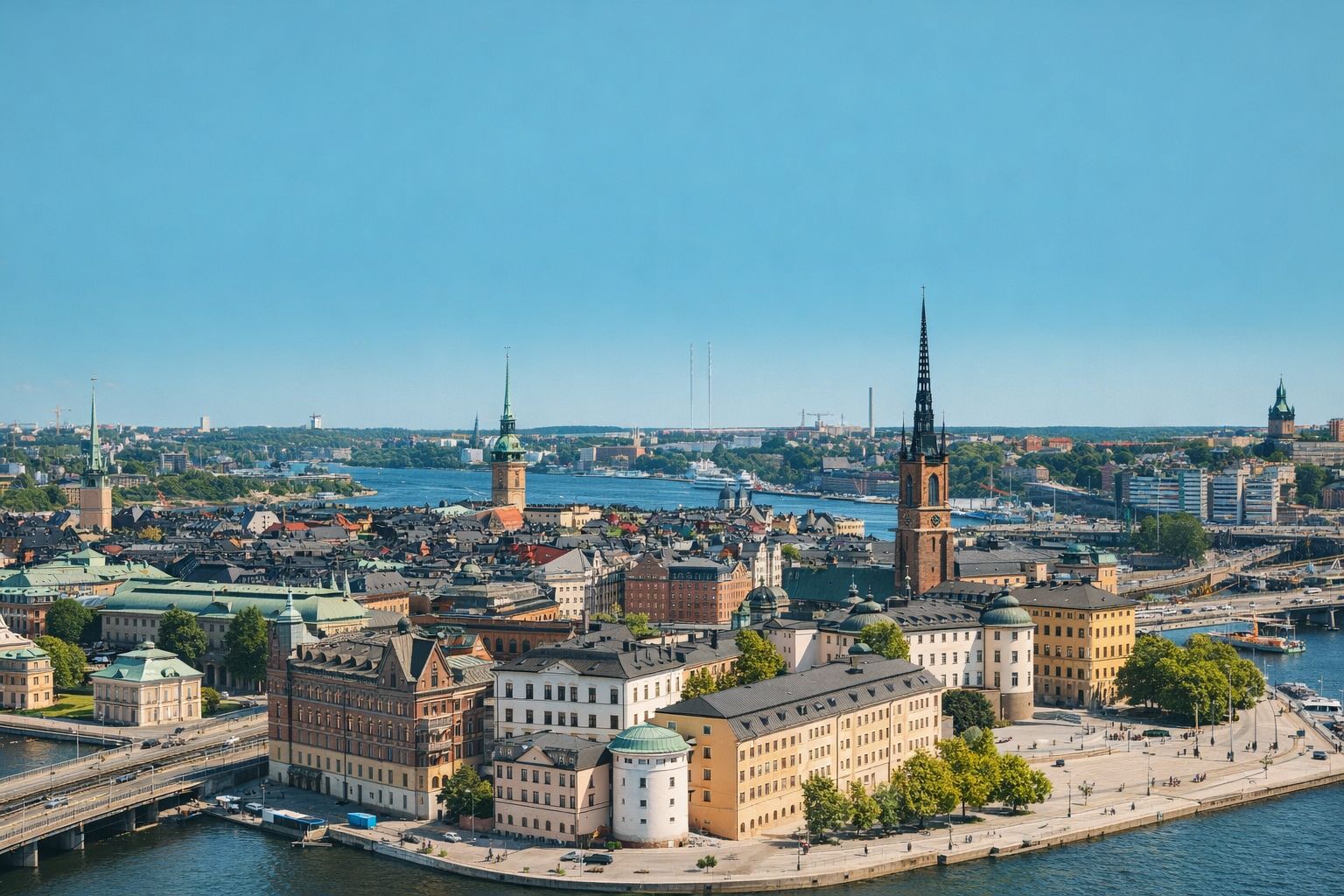 Panoramavy över Stockholms innerstad med Riddarholmskyrkan i fokus under en klarblå himmel.